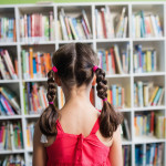 Rear view of a girl with braids in the library